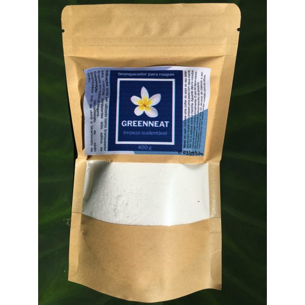 Embalagem kraft de cor marrom em cima de uma pela de madeira. Na embalagem um rótulo de cor azul com as informações do produto que é o branqueador de roupas